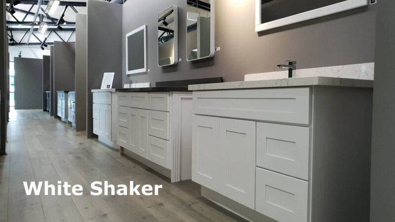 White shaker-style kitchen cabinets with mirrors above.