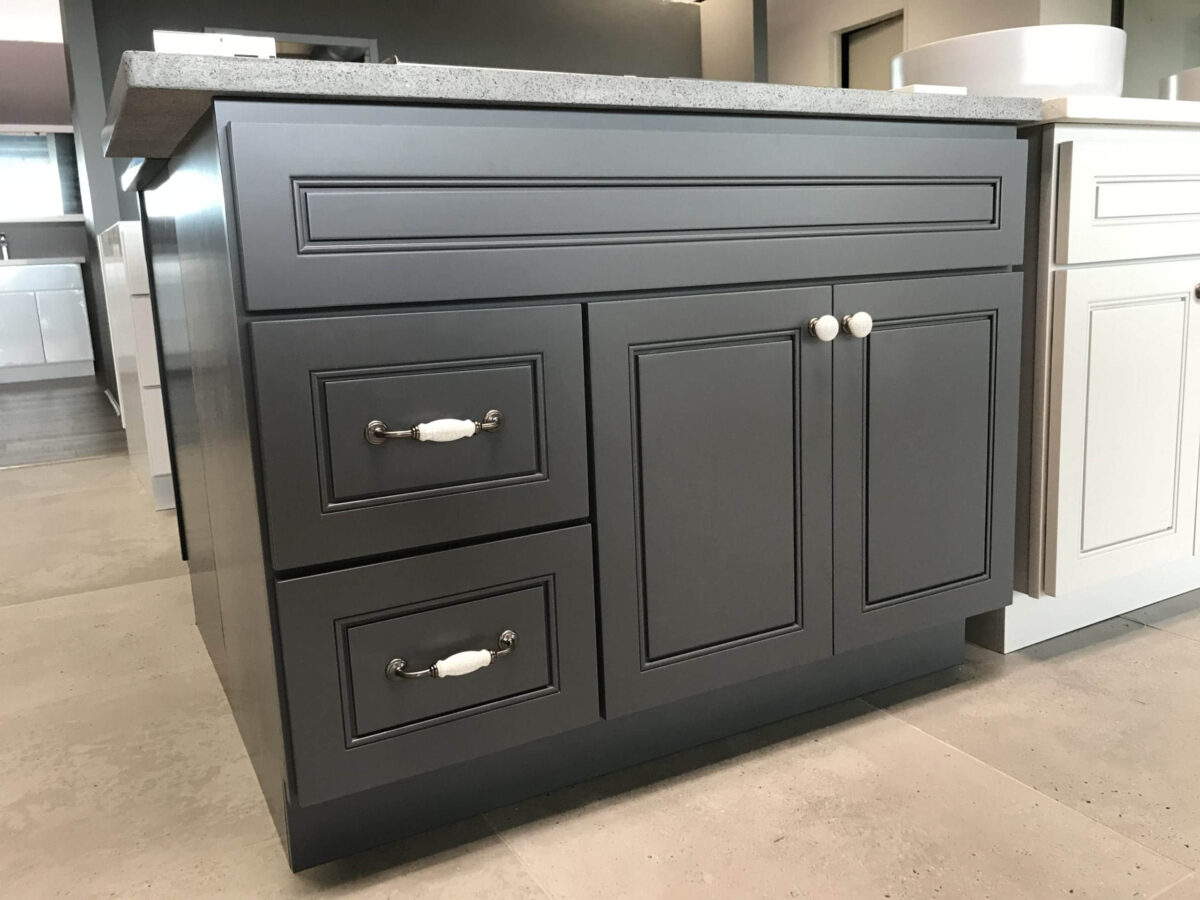 Grey kitchen island with drawers and granite countertop.