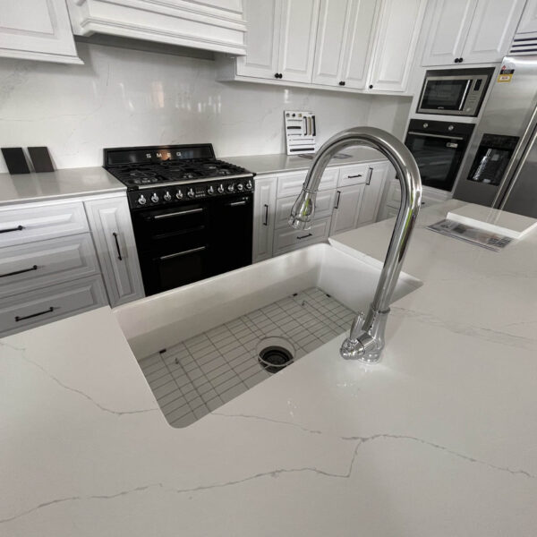 Modern kitchen with white cabinets and stainless steel appliances.