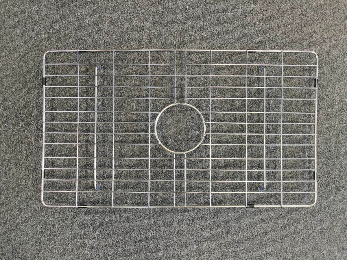 Metal sink protector on a gray surface.