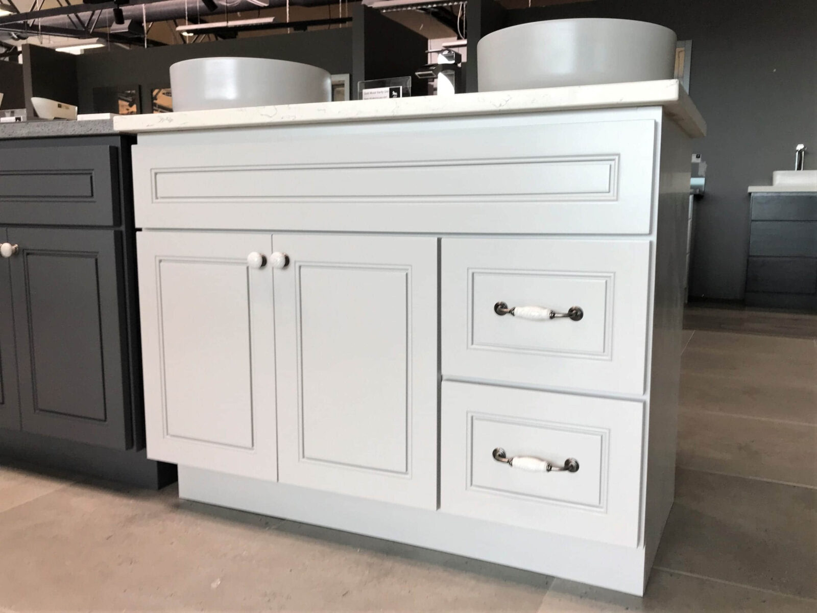 Light gray kitchen cabinet with drawers and round handles.
