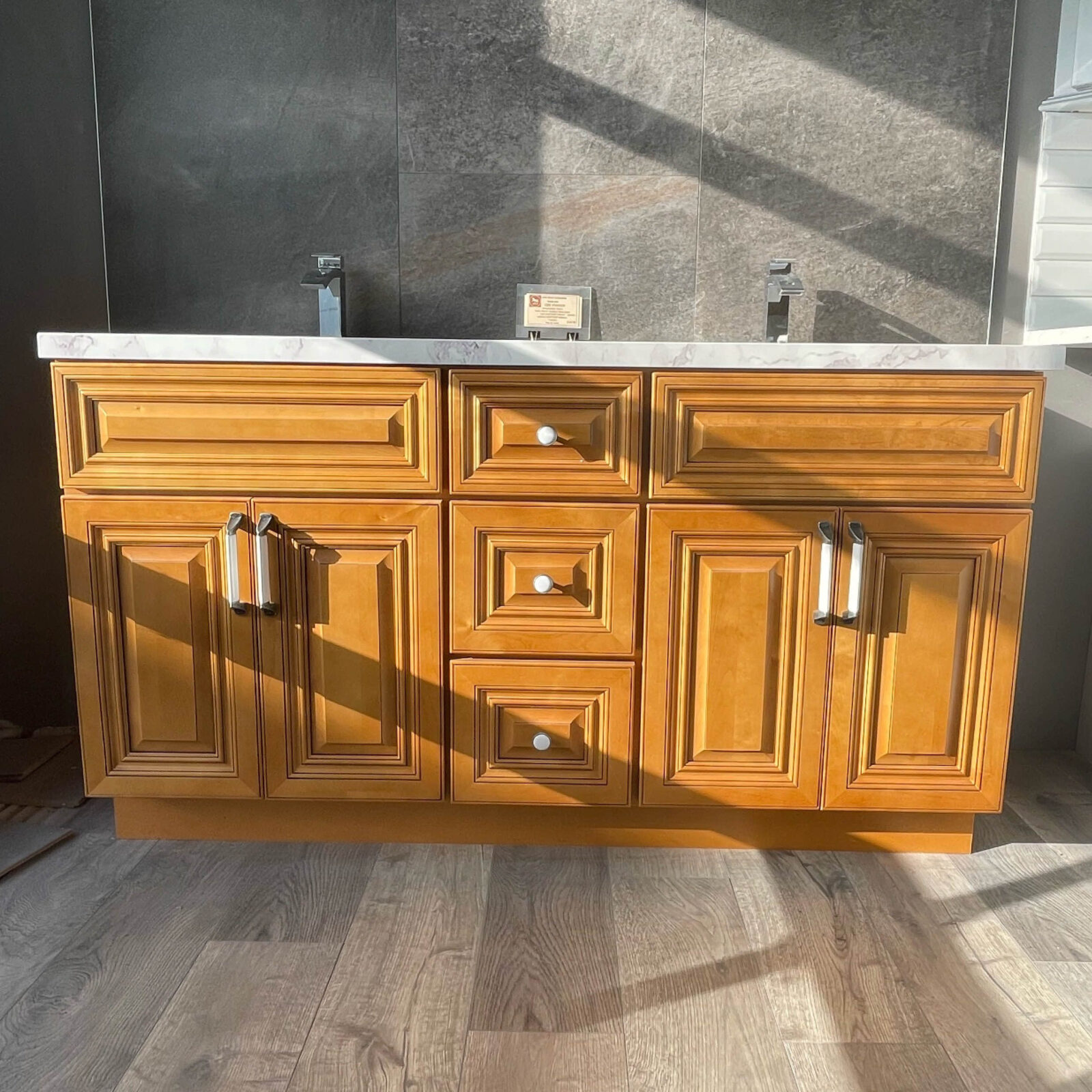 OAK-5920-1.jpg Wooden kitchen cabinet with marble countertop in sunlight.