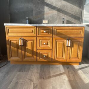 Wooden kitchen cabinet with marble countertop in sunlight.