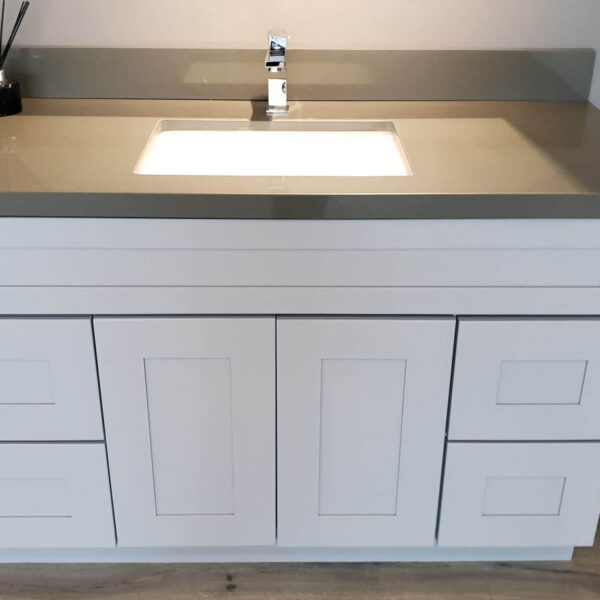 Modern white bathroom vanity with gray countertop and sink.