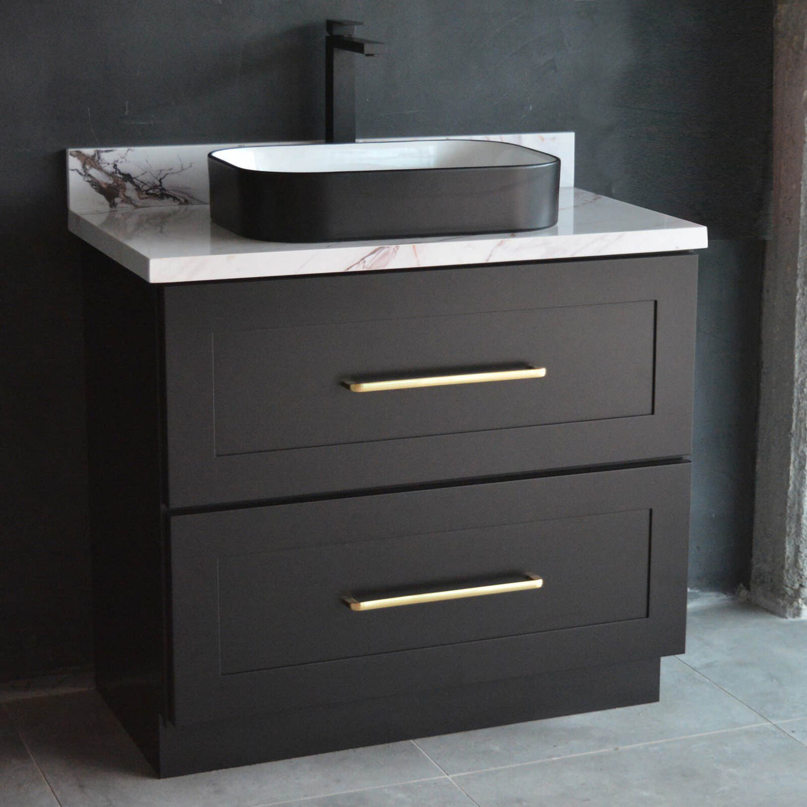 Black bathroom vanity with marble countertop and modern faucet.