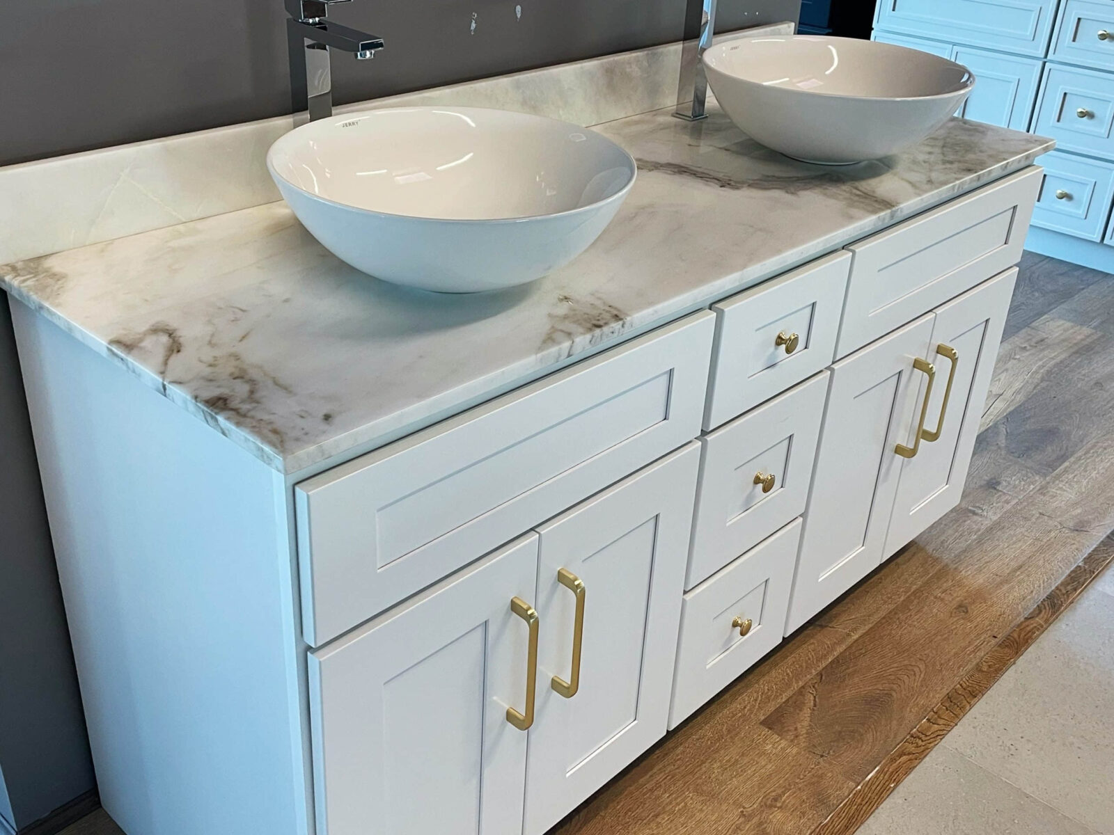 White marble bathroom vanity with dual sinks and gold handles.