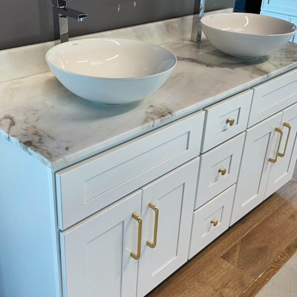 White marble bathroom vanity with dual sinks and gold handles.