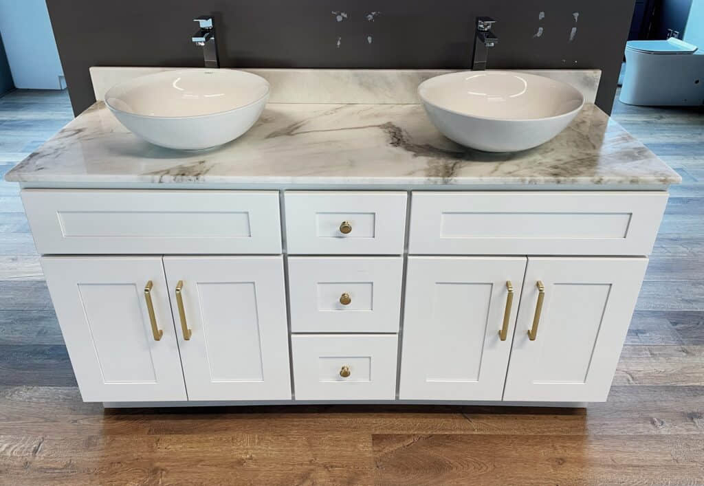 White marble double sink vanity with gold handles on wooden floor.