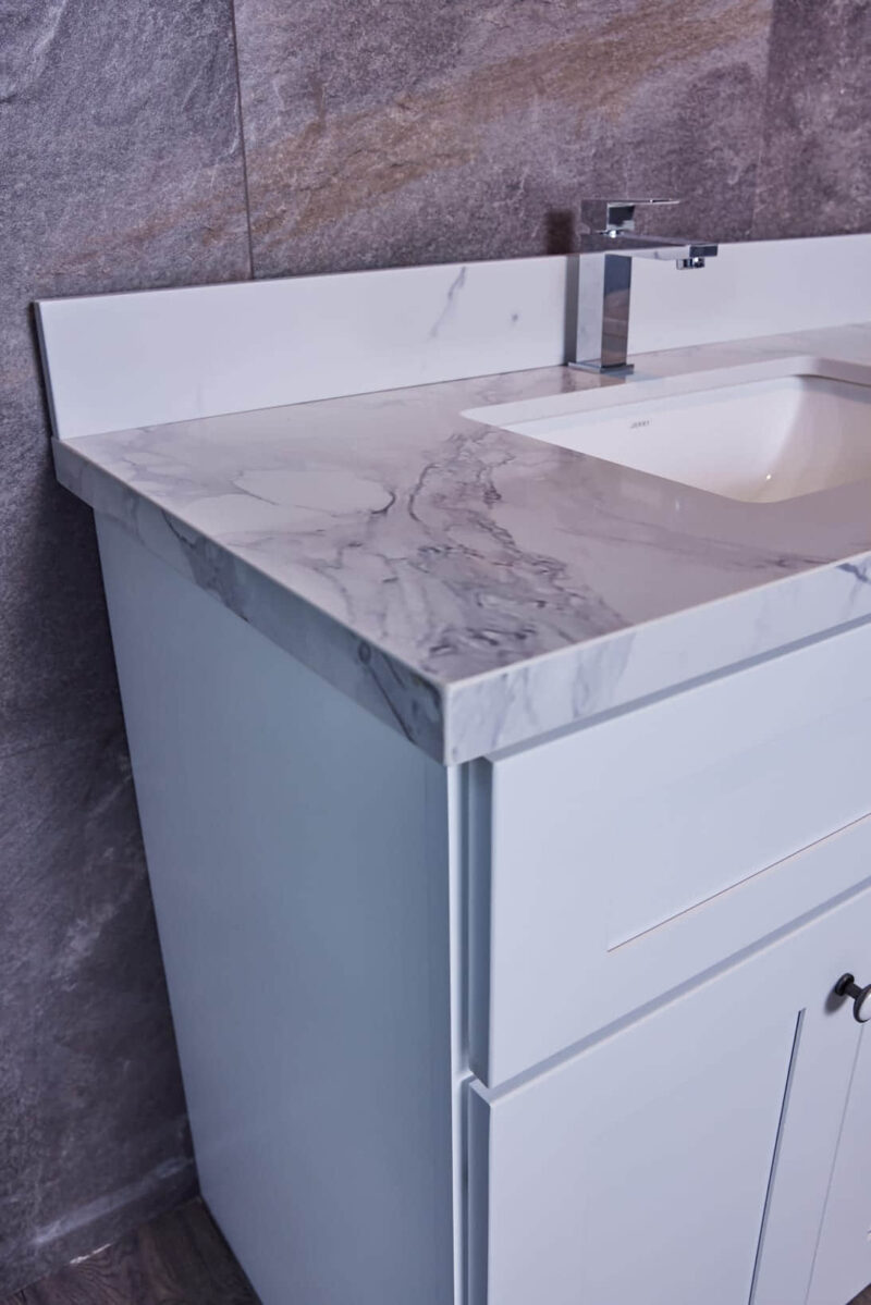 Modern bathroom vanity with marble countertop and sleek faucet.