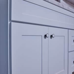 White kitchen cabinet with modern handles.