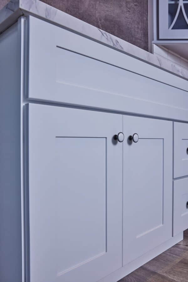 White kitchen cabinet with modern handles.