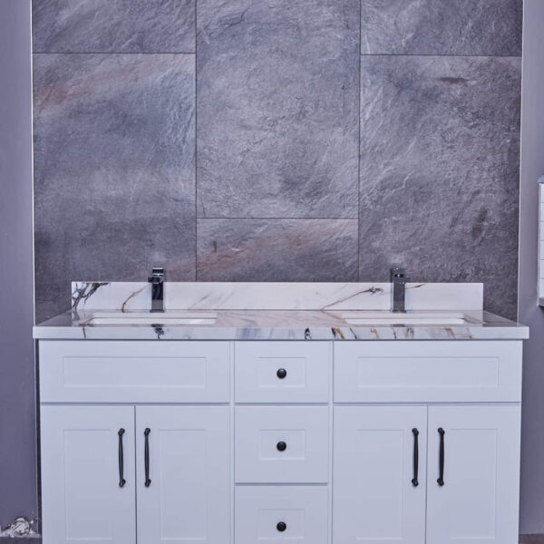 White bathroom vanity with marble countertop and gray tiled wall background.