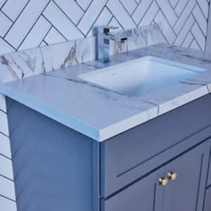 Modern bathroom sink with marble countertop and blue cabinet.