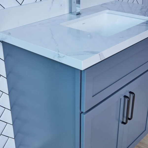 Blue bathroom vanity with marble countertop and modern handles.