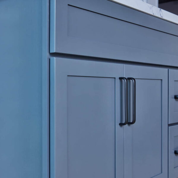 Blue kitchen cabinet with black handles.