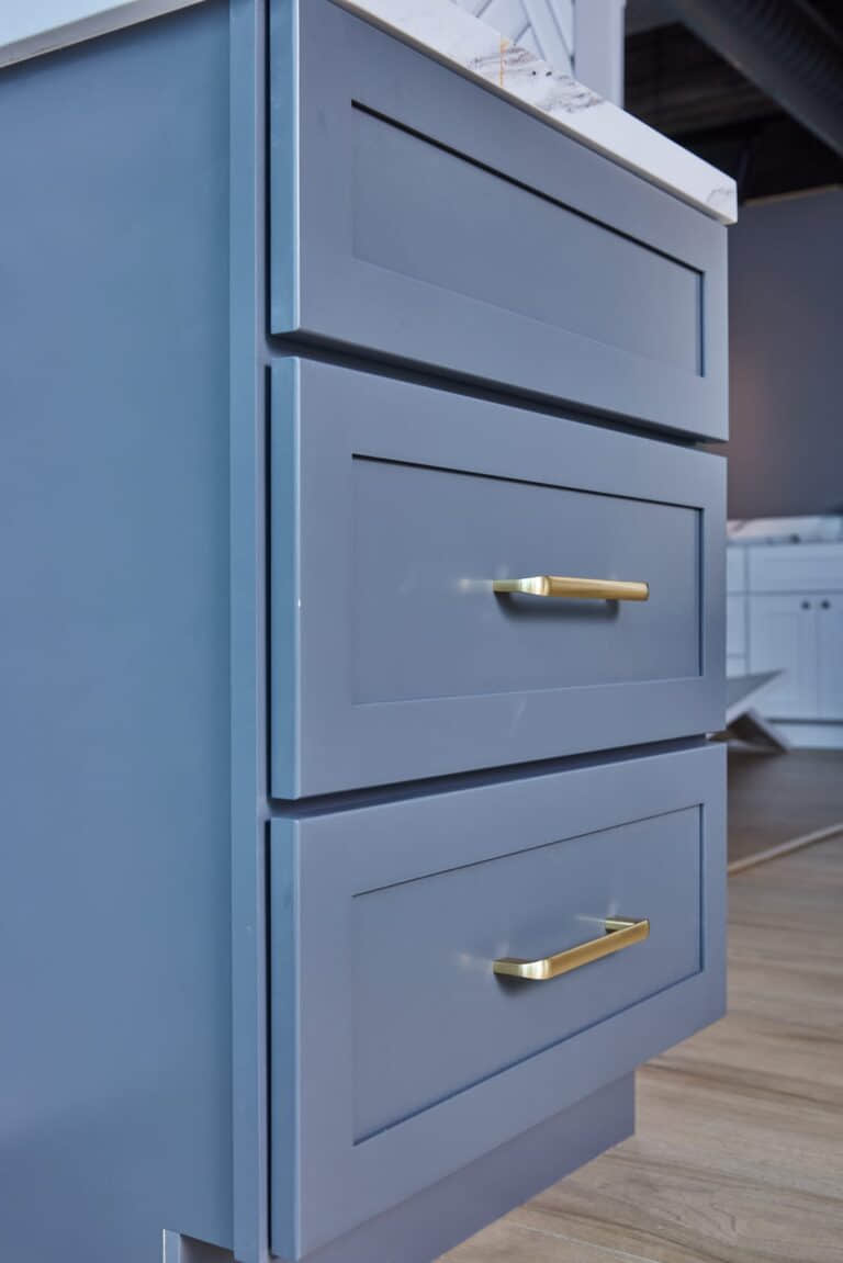 Blue kitchen cabinets with gold handles in modern design.