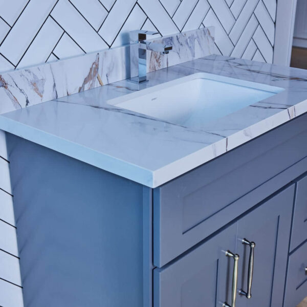 Modern bathroom vanity with marble countertop and blue cabinet.