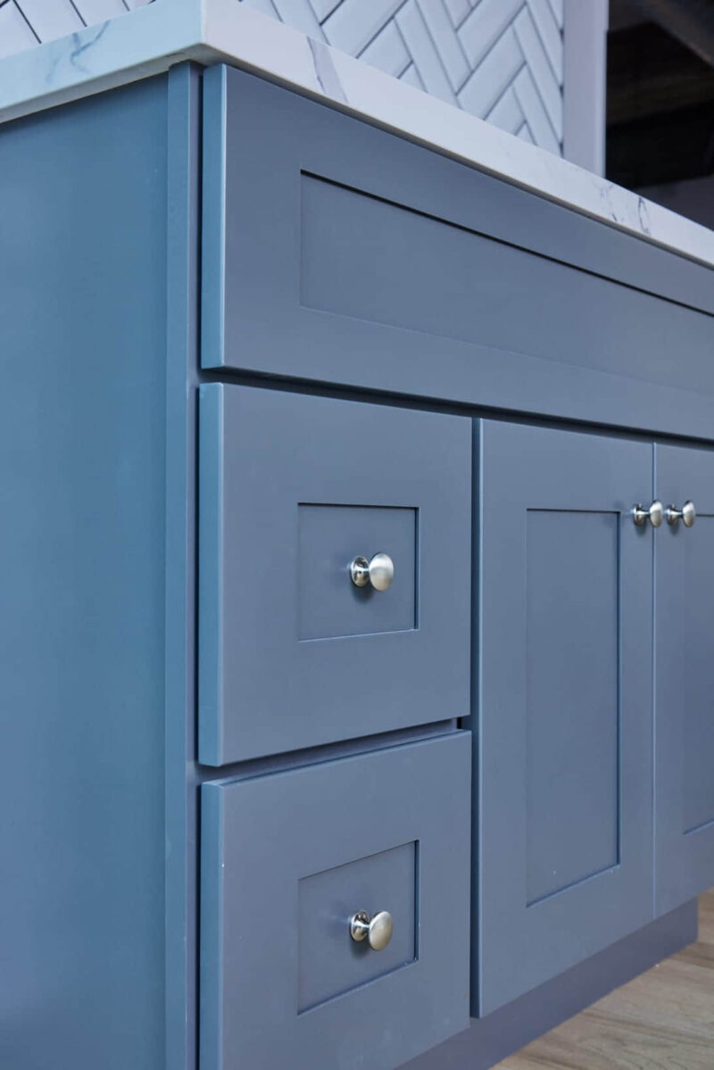 Blue kitchen cabinet with silver knobs.