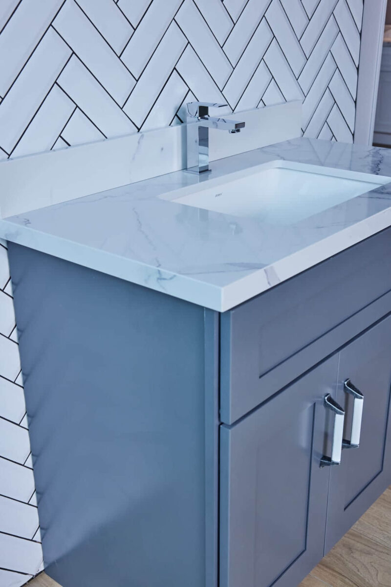 Blue bathroom vanity with marble countertop and modern faucet.