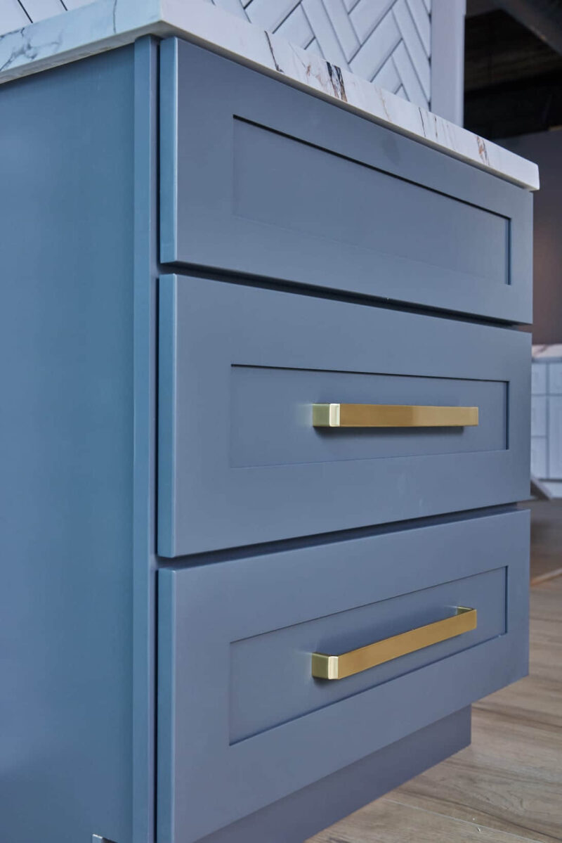 Blue kitchen drawers with gold handles.