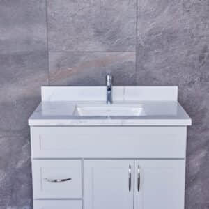 White bathroom vanity with marble countertop and modern faucet.