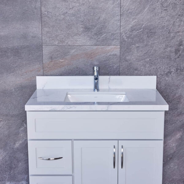 White bathroom vanity with marble countertop and modern faucet.