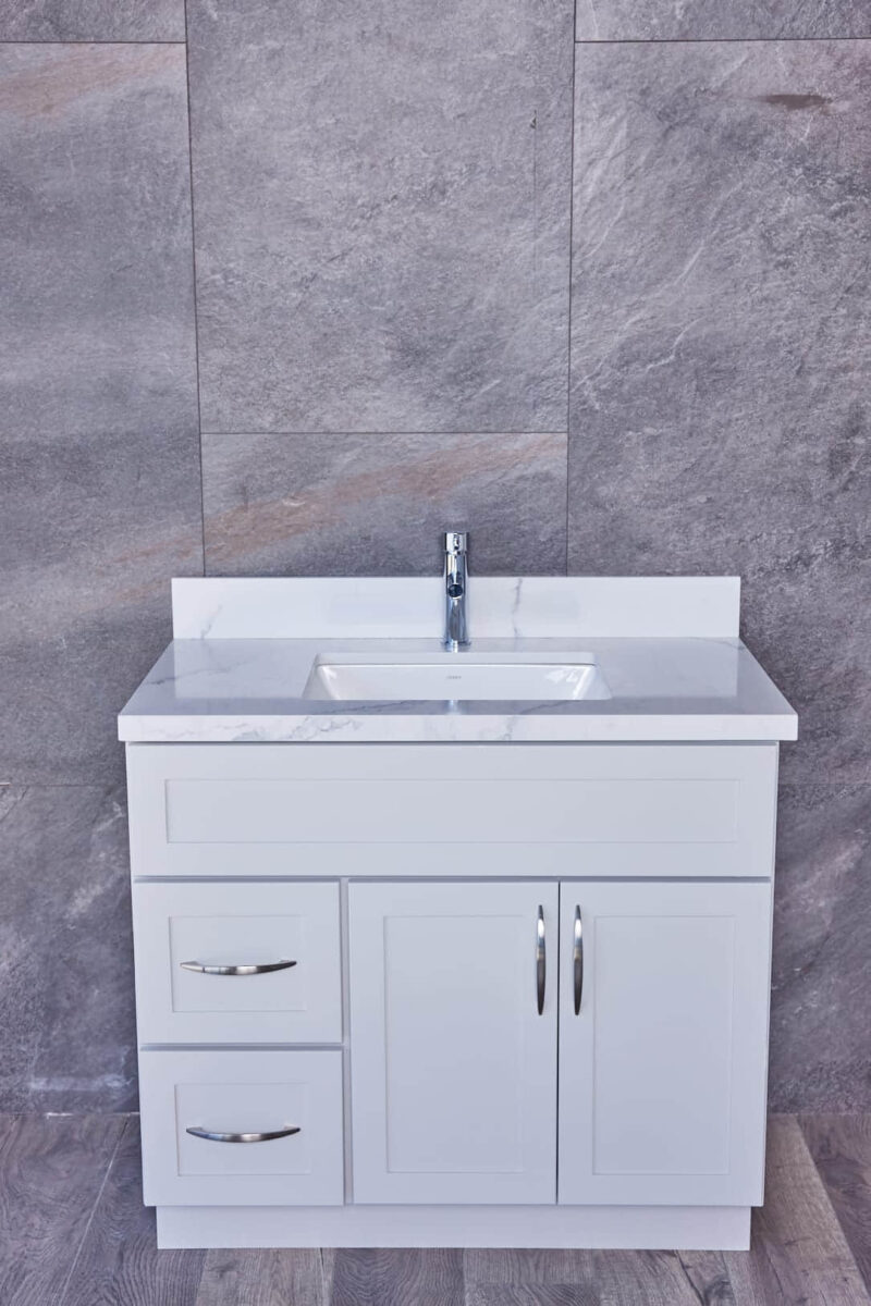 White bathroom vanity with marble countertop and modern faucet.