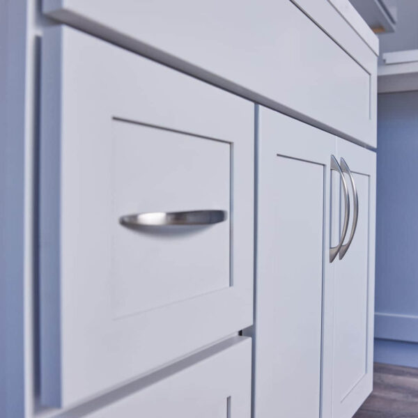 White kitchen cabinets with silver handles, close-up view.