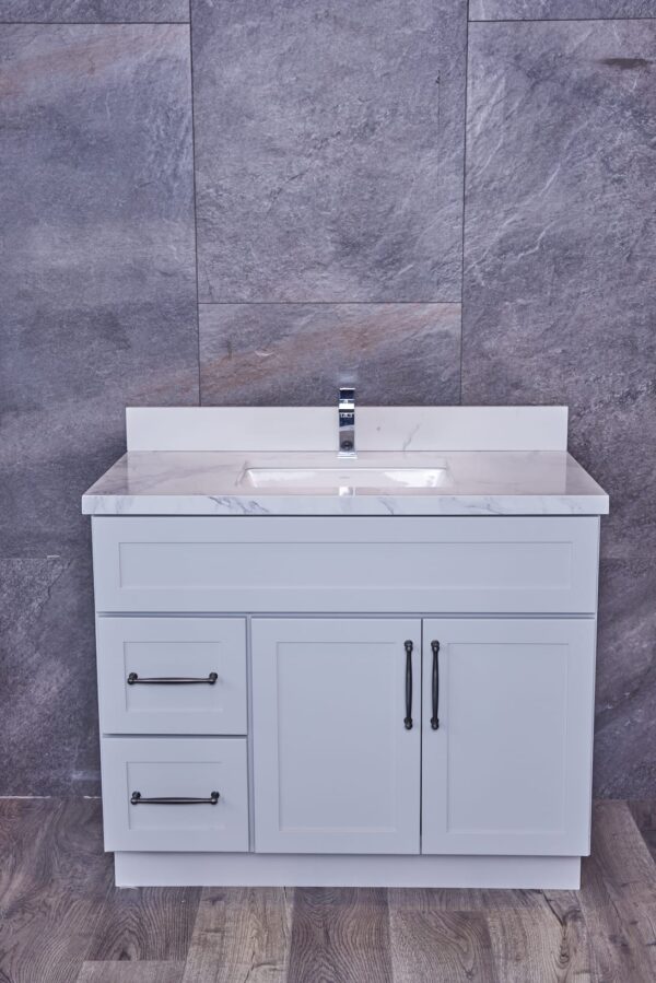 White bathroom vanity with marble countertop and modern faucet.
