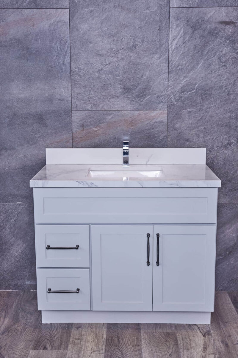 White bathroom vanity with marble countertop and gray tile background.