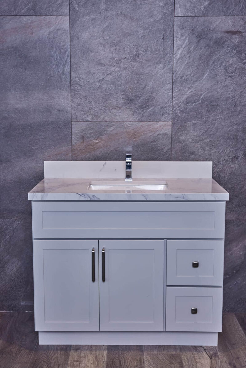 Gray bathroom vanity with marble countertop and modern faucet.