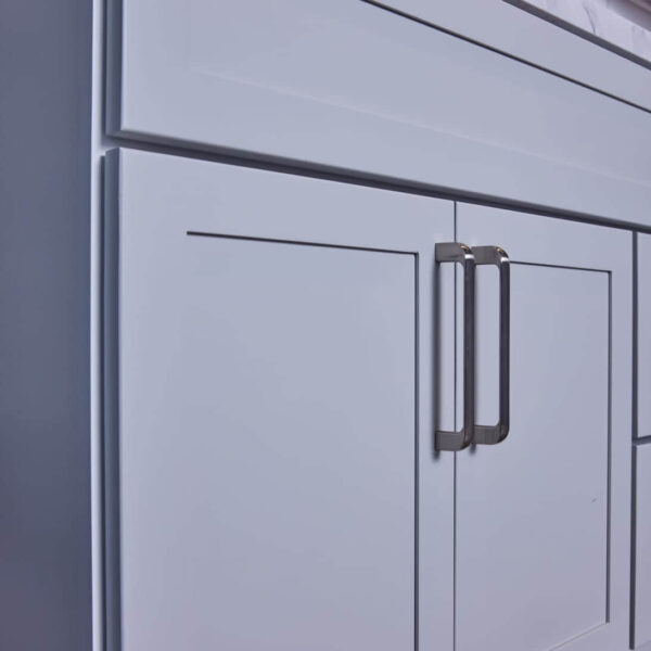 White kitchen cabinet with modern handles.