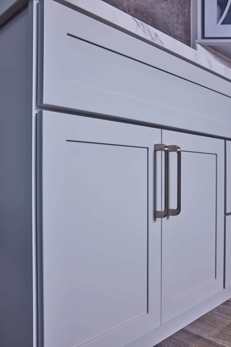 White kitchen cabinet with modern handles.