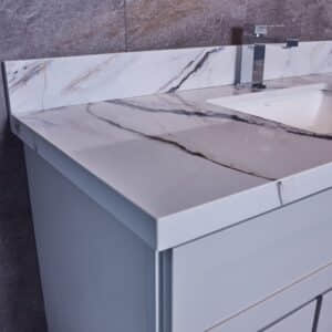 Marble bathroom vanity with modern faucet and backsplash.
