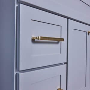 White kitchen cabinets with gold handles.