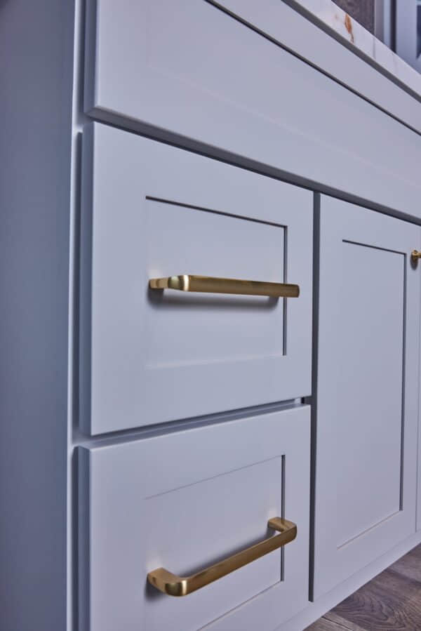 White kitchen cabinets with gold handles.
