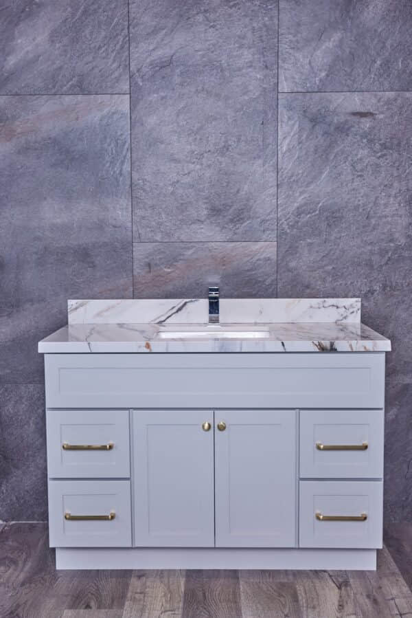 Modern bathroom vanity with marble countertop and gray cabinets.