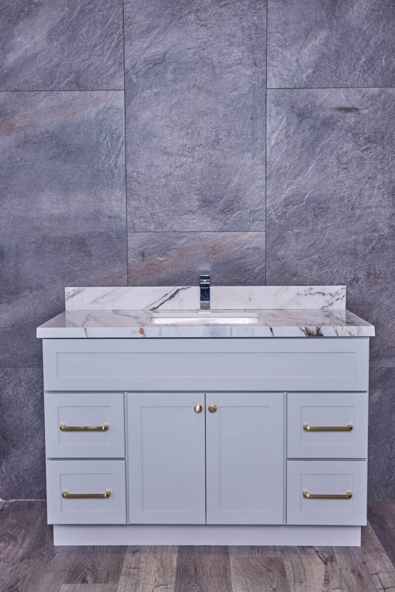 Modern bathroom vanity with marble countertop and gray cabinets.