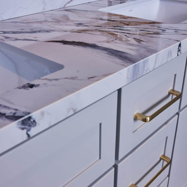 Marble countertop with gold handles on white cabinets.