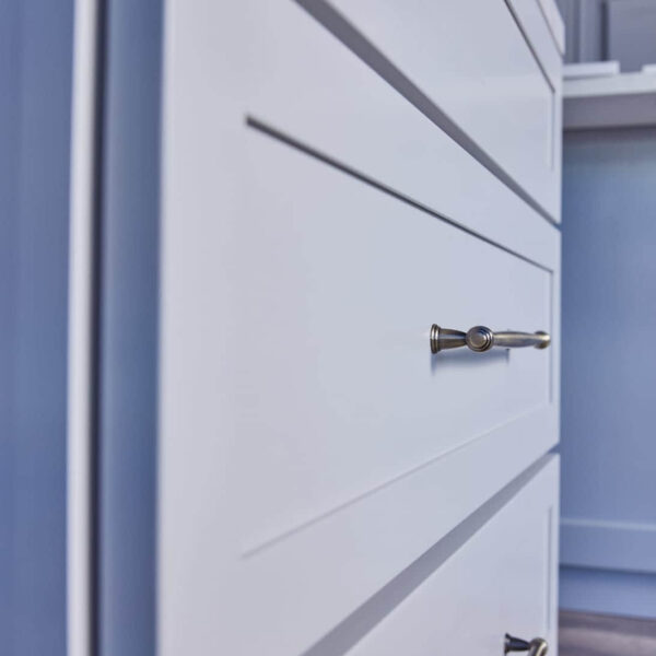 White kitchen cabinet with sleek metal handle.