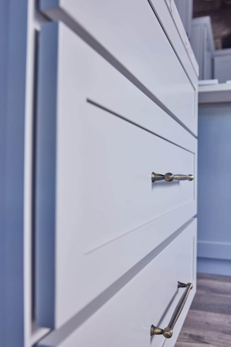 White kitchen cabinet with sleek metal handle.
