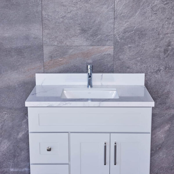 White bathroom vanity with marble countertop and modern faucet.