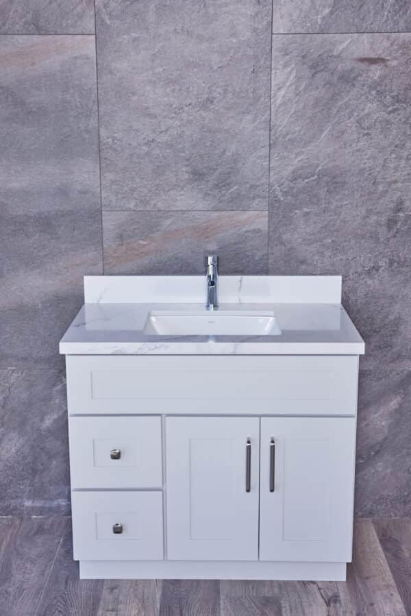 White bathroom vanity with marble countertop and modern faucet.