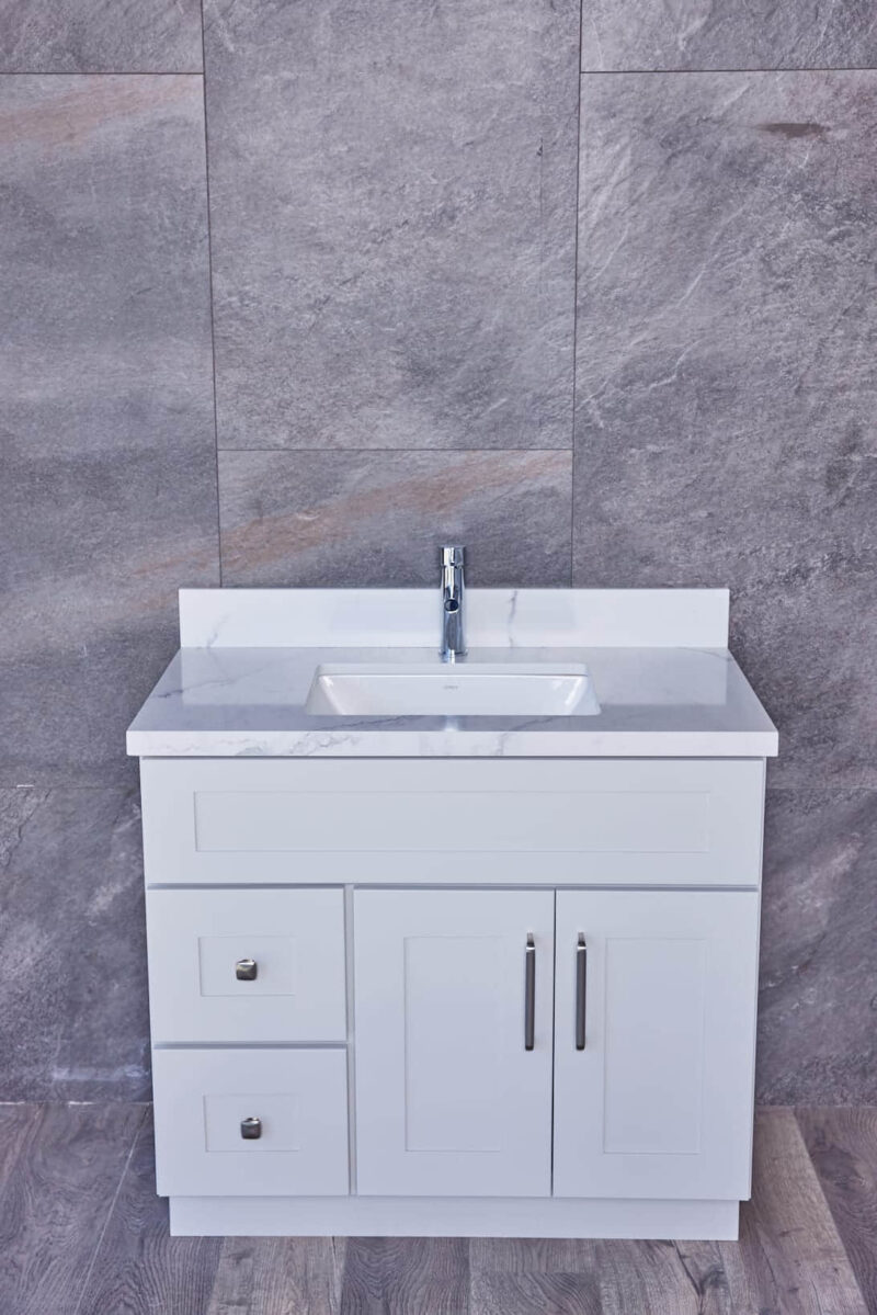 White bathroom vanity with marble countertop and modern faucet.