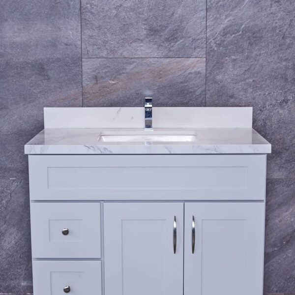 White bathroom vanity with marble countertop and modern faucet.