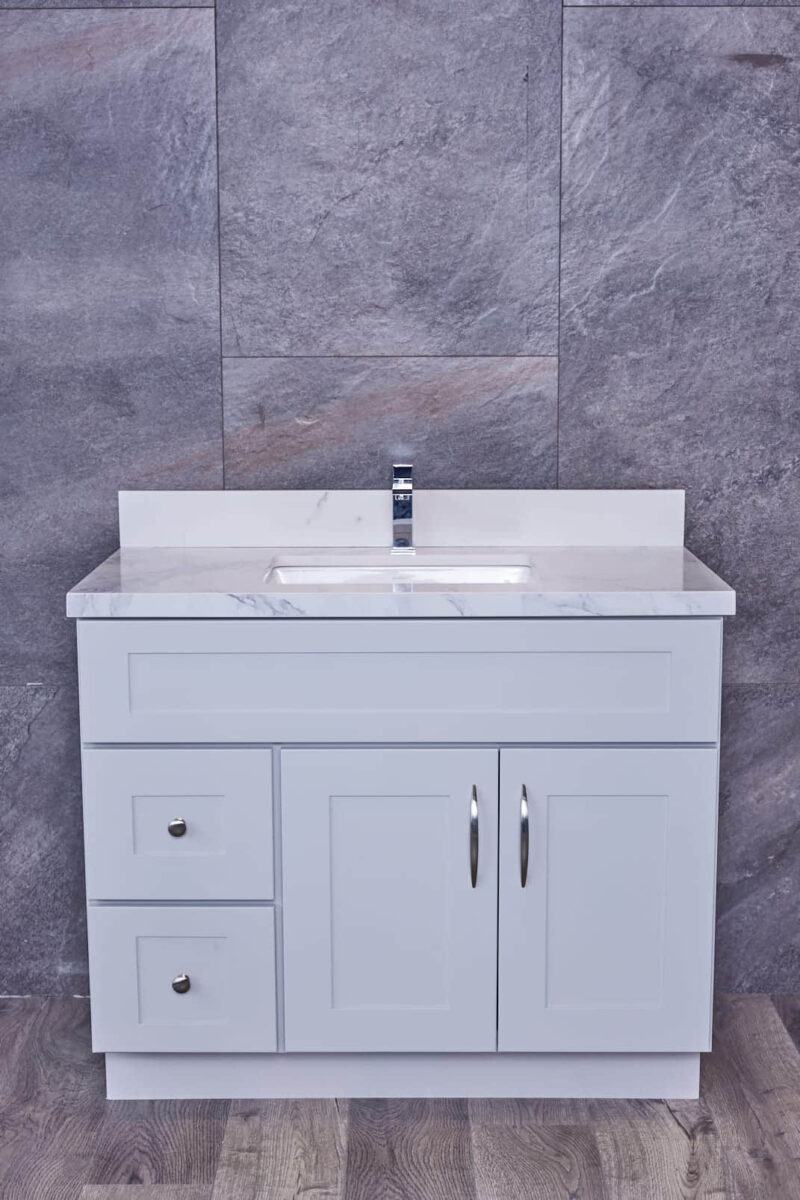 White bathroom vanity with marble countertop and modern faucet.