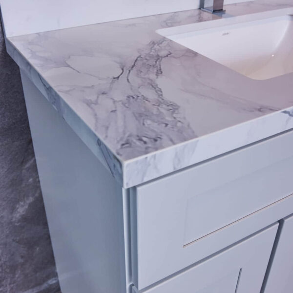 Modern bathroom vanity with marble countertop and sleek faucet.