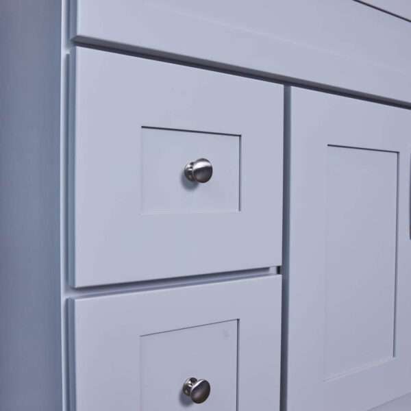White kitchen cabinet with silver knobs.