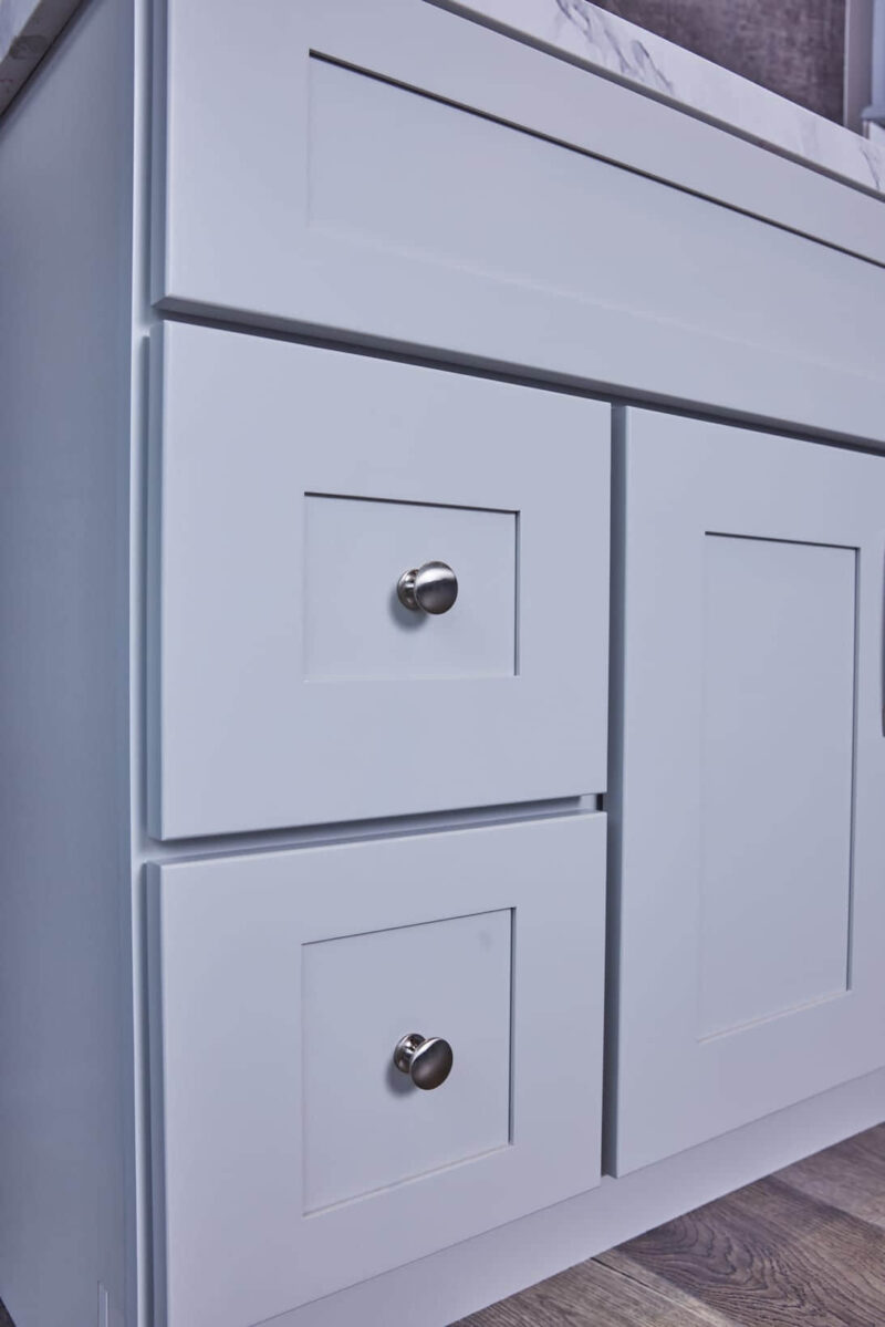 White kitchen cabinet with silver knobs.