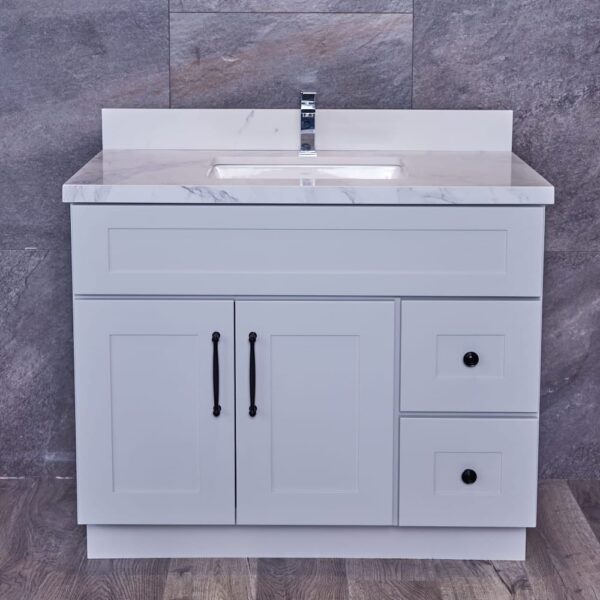 White bathroom vanity with marble countertop and modern faucet.